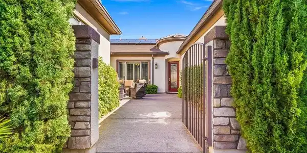 Image 3: A gated entry path lined with stone pillars and ma