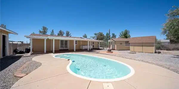 Image 2: An inviting backyard oasis offers a free-form pool