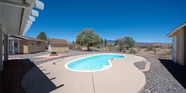 Image 3: An inviting backyard oasis offers a free-form pool