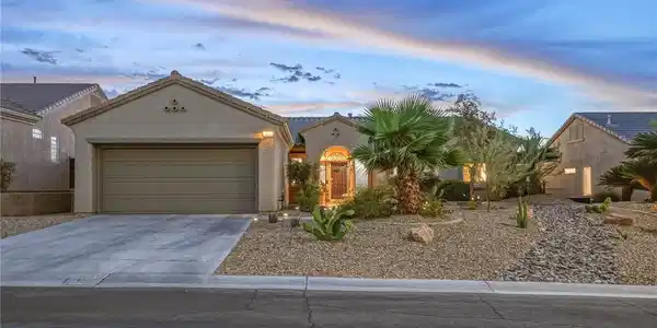 Image 2: Desert landscaping and a stucco exterior frame thi