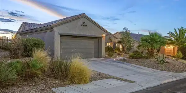 Image 3: Desert landscaping and a concrete driveway frame t