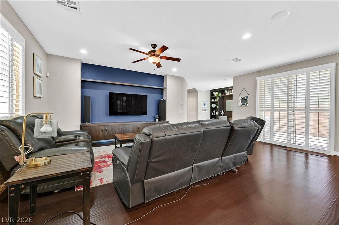 Image 4: A well-lit living space features rich hardwood flo