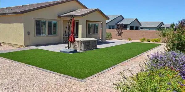Image 2: A private backyard oasis features artificial turf,