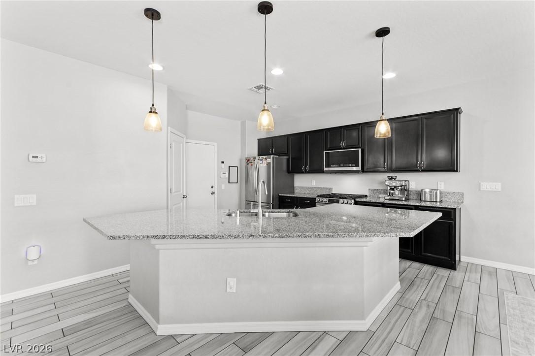 Image 3: A contemporary kitchen features dark cabinetry, gr