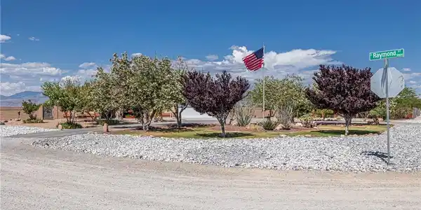 Image 2: A corner lot with mature trees and desert landscap