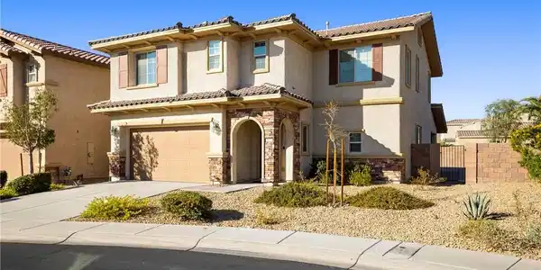 Image 2: An arched stone entryway and tile roof define the