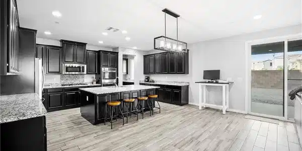 Image 4: Granite countertops and dark cabinetry define this