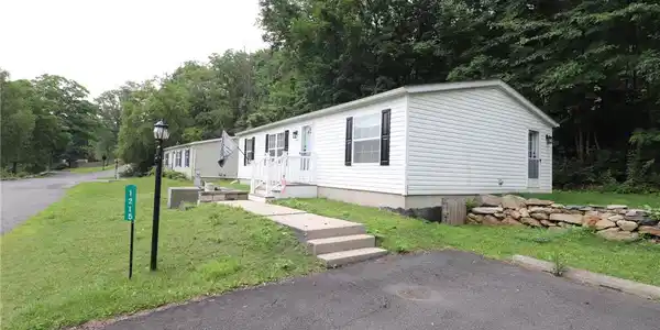 Image 3: White siding and dark shutters provide curb appeal