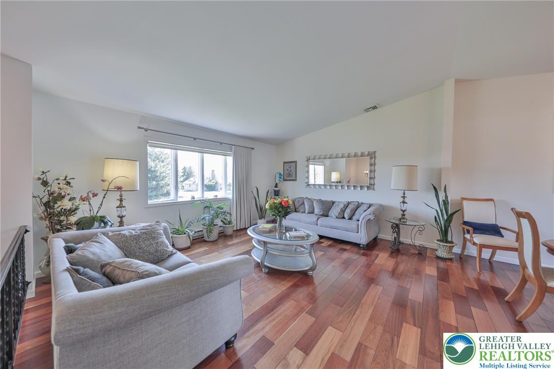 Image 4: Rich hardwood floors flow through this light-fille