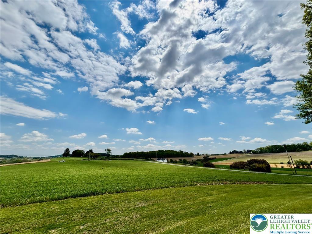 Image 4: Expansive green fields unfold under a brilliant sk