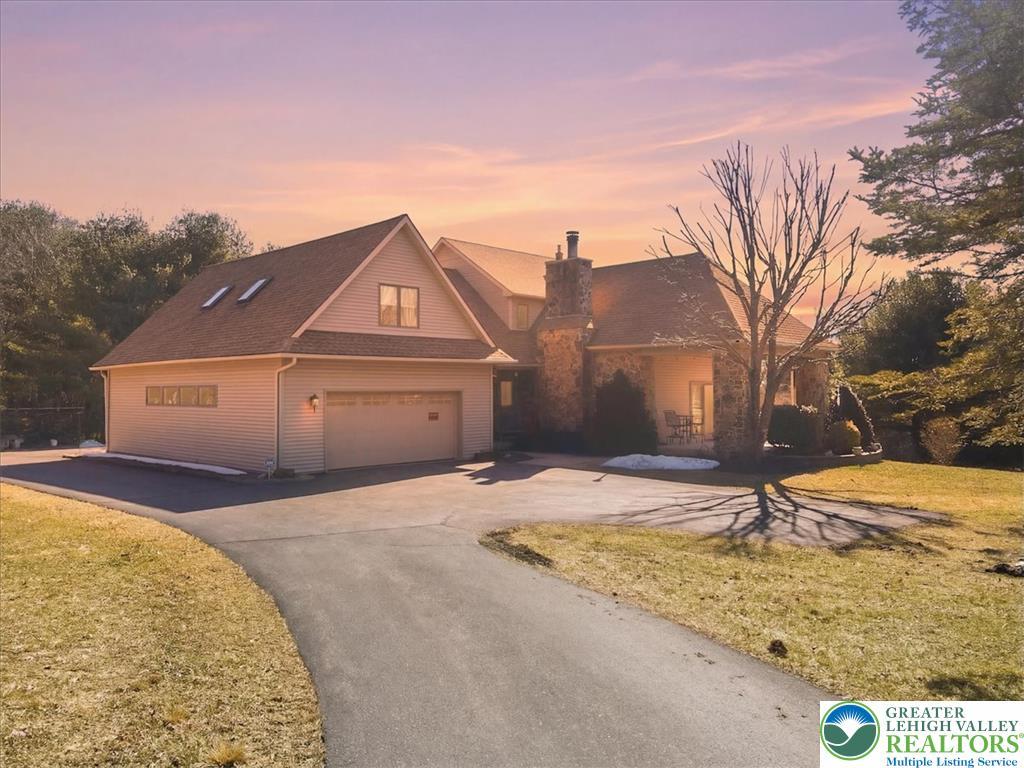 Image 2: A grand, stone-accented home with an attached gara
