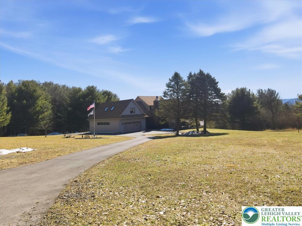 Image 3: A sweeping paved driveway leads to a welcoming hom