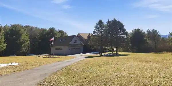 Image 3: A sweeping paved driveway leads to a welcoming hom
