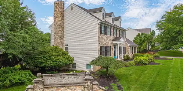 Image 3: A stone-and-siding exterior rises above a manicure