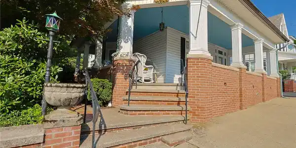 Image 4: Welcoming brick steps lead up to a classic covered