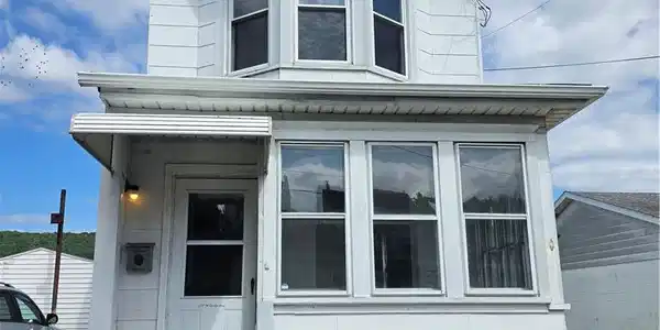 Image 2: Multi-pane windows and a framed entry porch define
