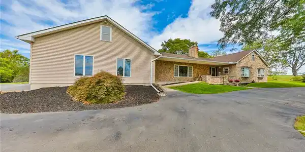 Image 3: A spacious paved driveway leads to this classic ho