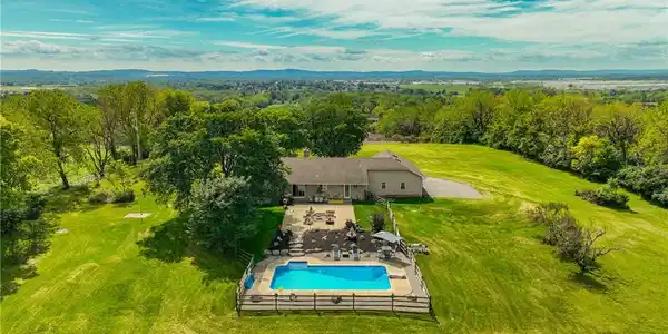 Image 4: Rolling green lawns surround a private swimming po