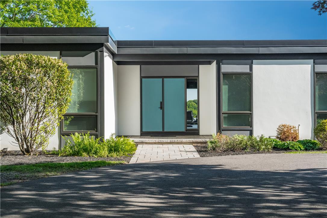 Image 2: Modern facade with a flat roof and striking teal d