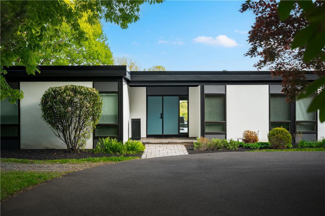 Image 4: A modern facade with striking dark window frames a