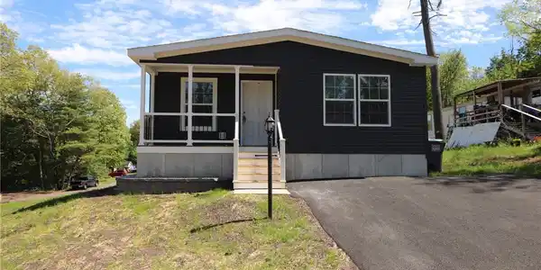 Image 2: A dark-paneled residence with an inviting front po