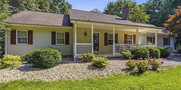Image 2: A welcoming front porch with white railings and st