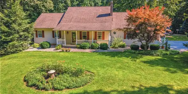 Image 4: A welcoming front porch enhances this charming res