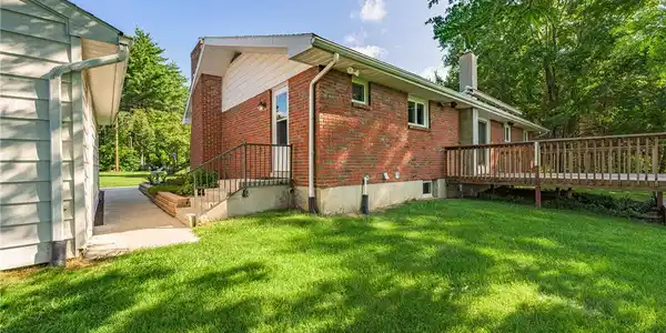 Image 3: A well-maintained lawn stretches beside a brick ex