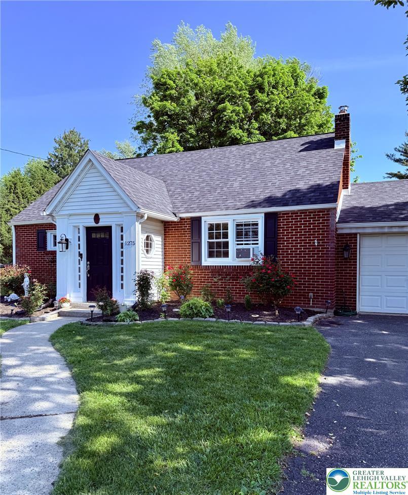 Image 2: A classic brick exterior welcomes with crisp white