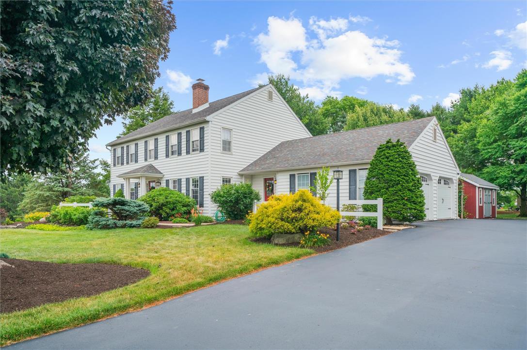 Image 3: A classic colonial home with vibrant landscaping a