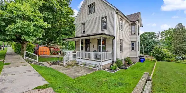 Image 2: Classic siding and a welcoming front porch define