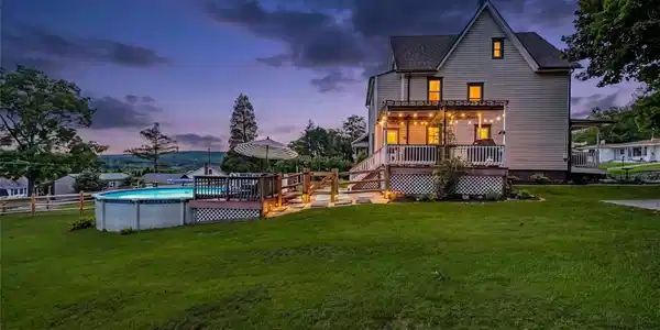 Image 3: An inviting back porch and above-ground pool defin
