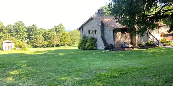 Image 3: Mature trees border a rolling green lawn highlight