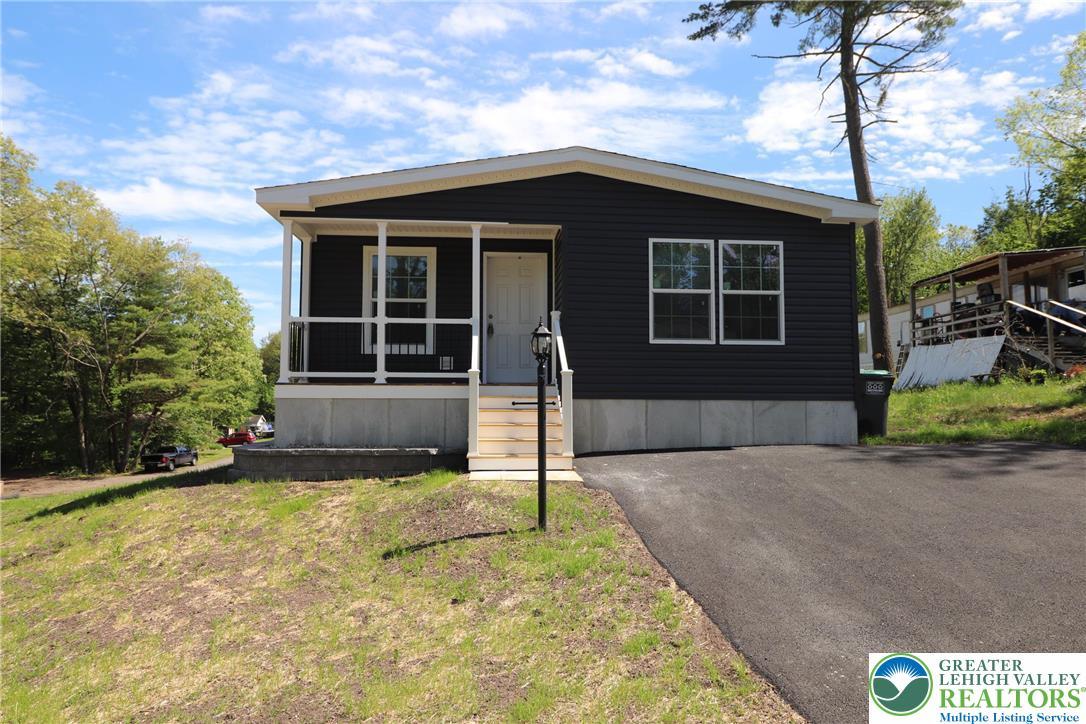 Image 2: A dark-paneled residence with an inviting front po