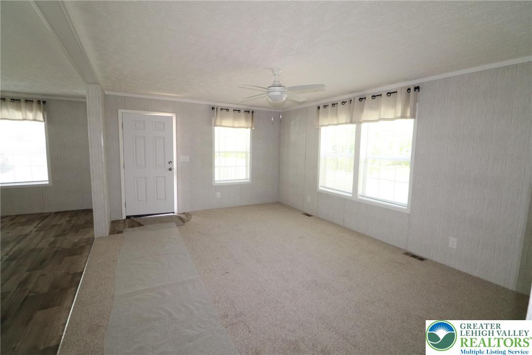 Image 3: A welcoming living area awaits with a ceiling fan