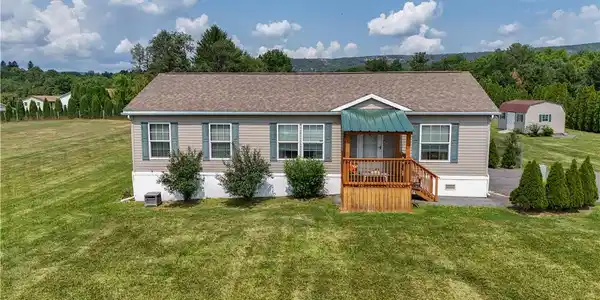 Image 3: A welcoming front porch enhances this charming, we
