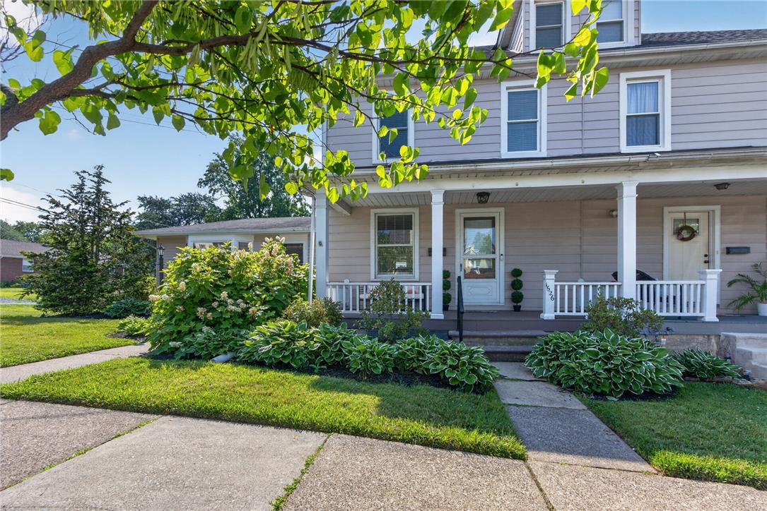 Image 3: A welcoming front porch with white railings graces