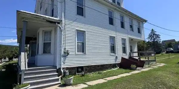 Image 3: Vinyl siding and multiple windows define the side