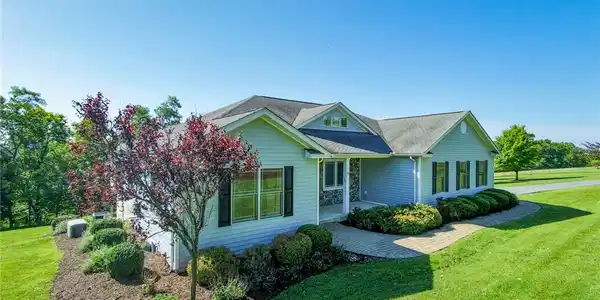Image 2: Manicured landscaping surrounds this classic singl