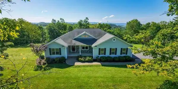 Image 3: Manicured landscaping surrounds this classic singl