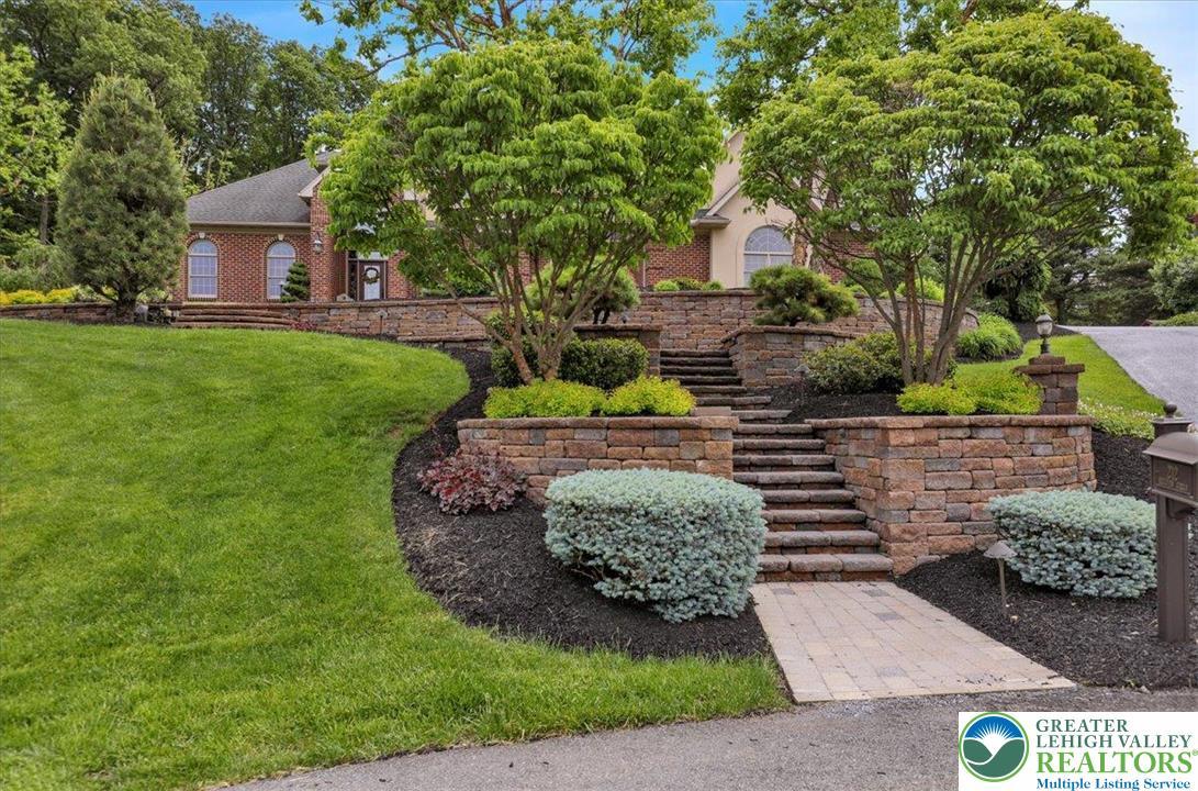 Image 4: Terraced landscaping and a brick facade frame this