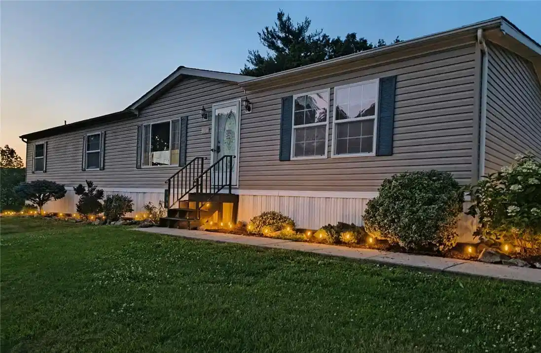 Image 1: Illuminated shrubs and manicured lawn highlight th