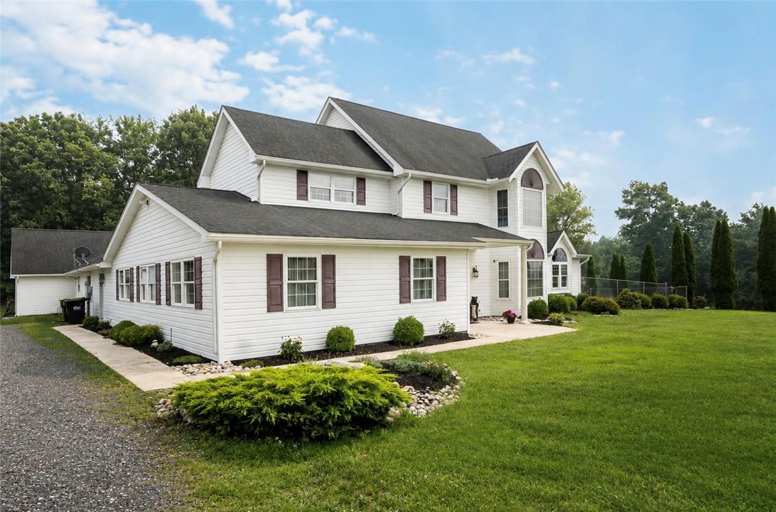 Image 2: A classic two-story residence with white siding an