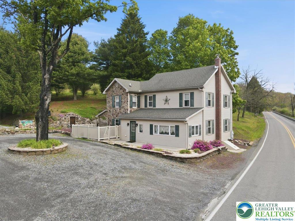 Image 3: This charming home features a timeless stone and s