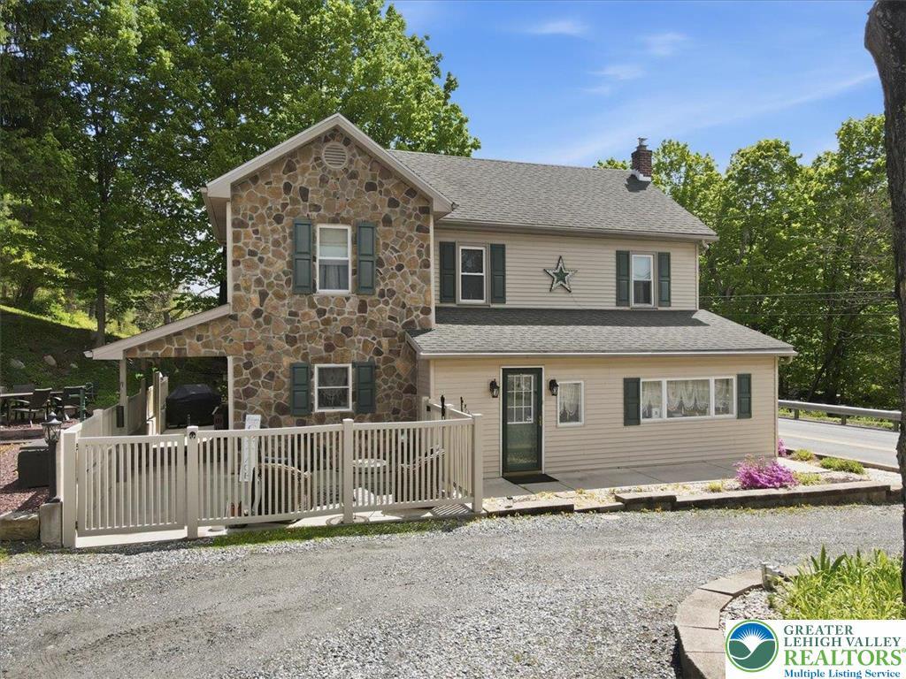 Image 4: This charming home features a captivating stone an