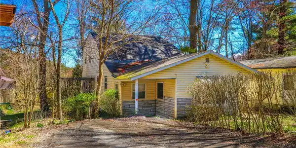 Image 2: A charming rustic dwelling featuring warm siding a