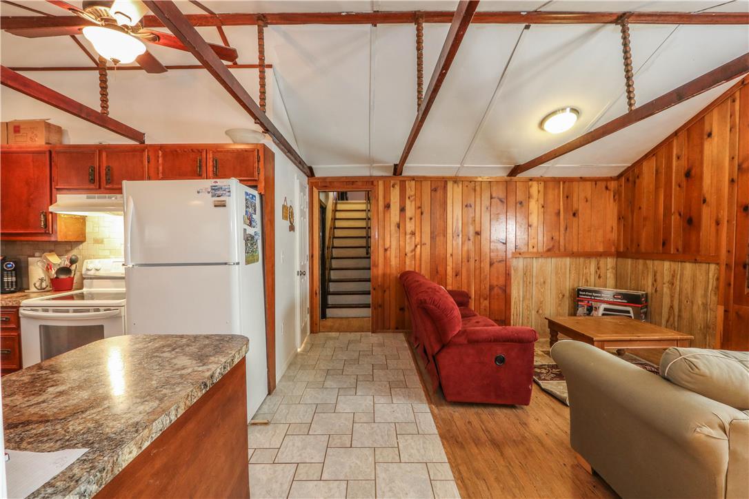 Image 4: A well-lit kitchen flows into a cozy living area w