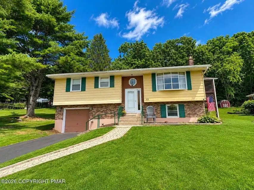 Image 1: A classic bi-level home featuring an attached gara