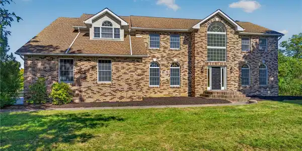 Image 2: A classic brick exterior and multiple gables creat