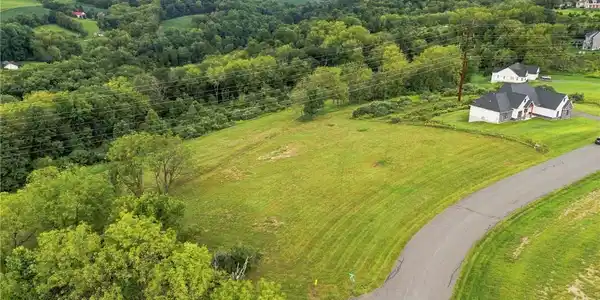 Image 2: Rolling green hills and mature trees frame this bu